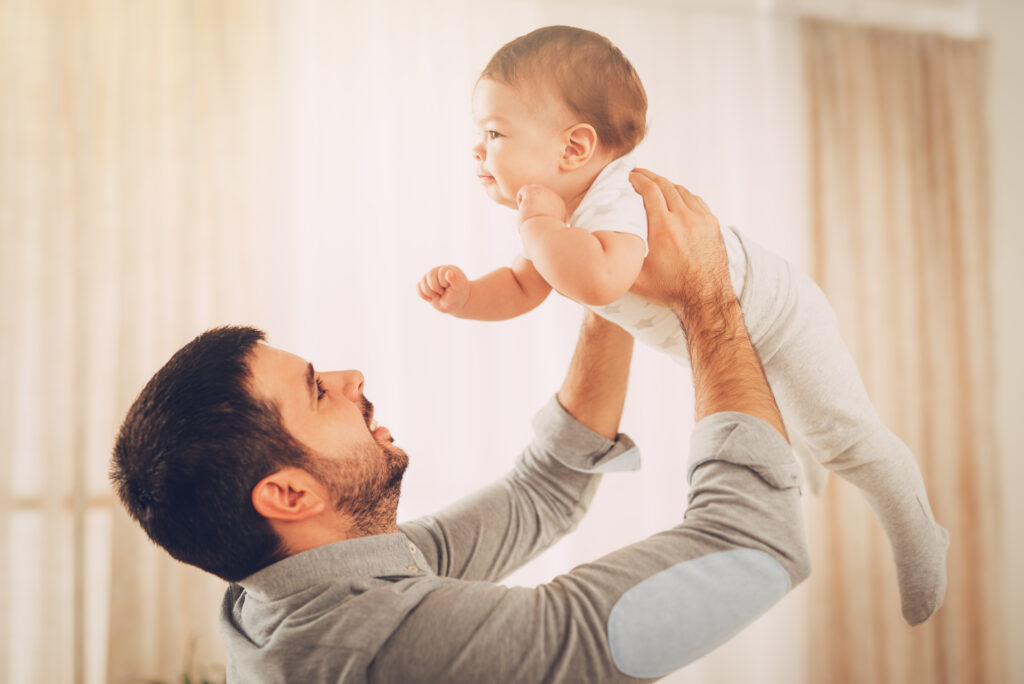beautiful young dad having fun with her cute baby boy home